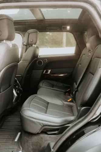 Clean dark leather rear seats beneath a panoramic roof.