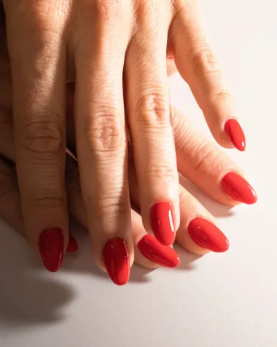 A close view of a glossy bright red manicure.